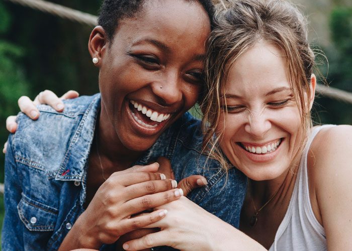 black and white smiling woman hugs